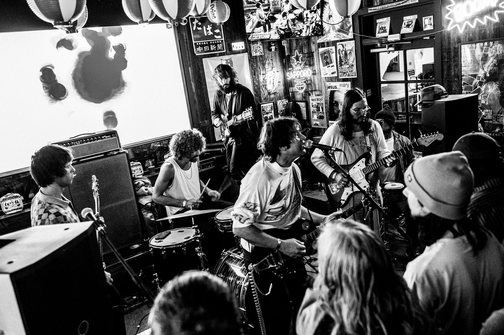 Black-and-white photo of a live rock band performing on stage